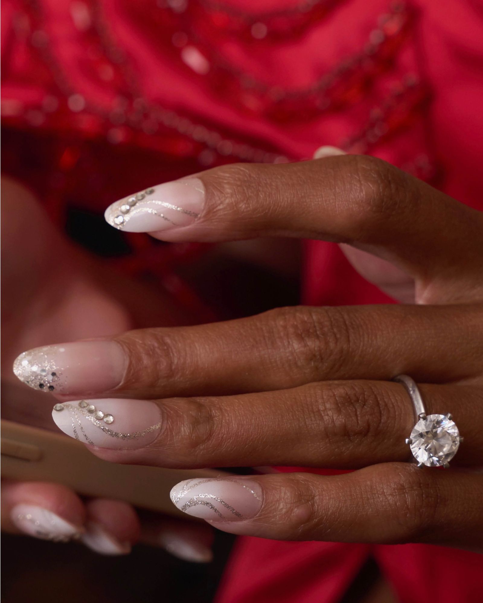 Ombre nude nails with silver gems and swirly silver lines.