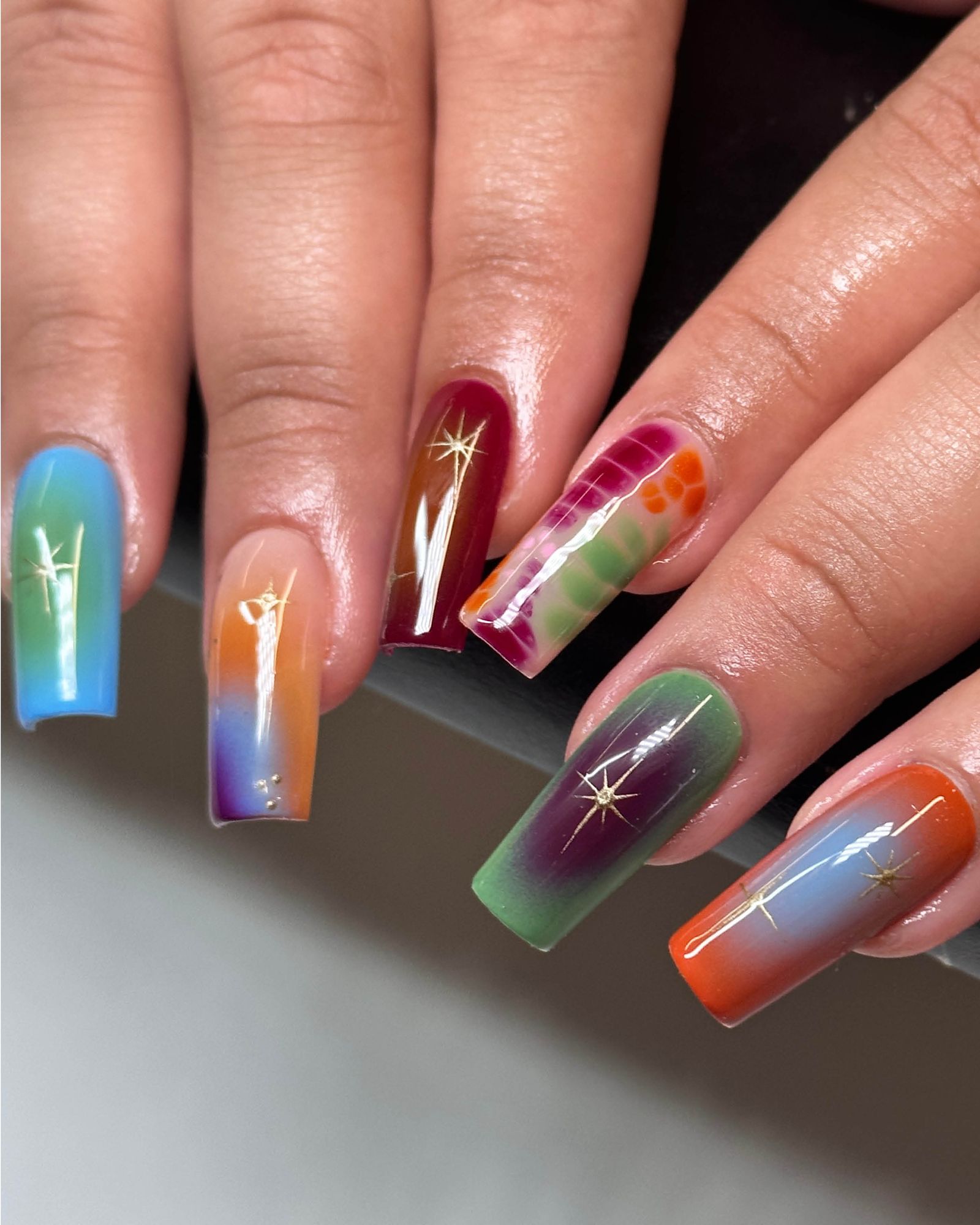 Multicolored aura squarecut nails with sparkle design.