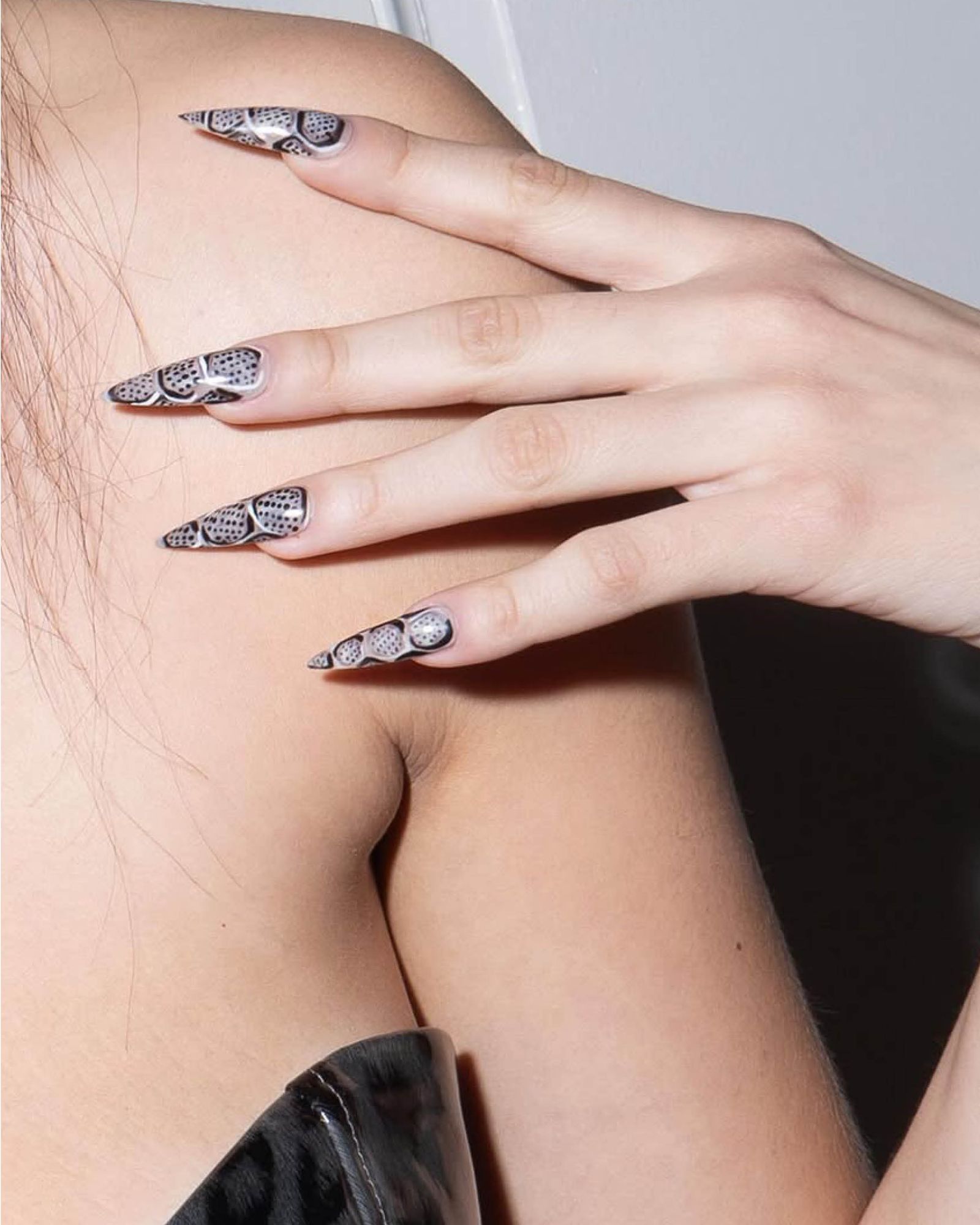 Raised silver design over white and black micro polka dot nail base.