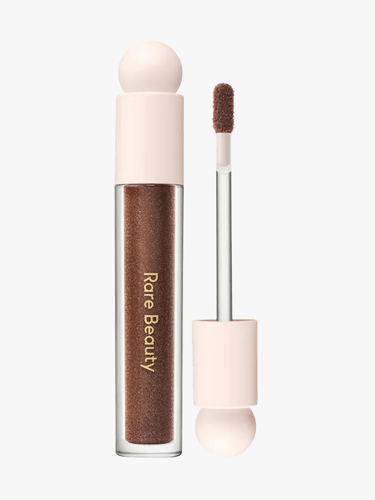 Rare Beauty Positive Light Luminizing Lip Gloss in branded component on a light gray background